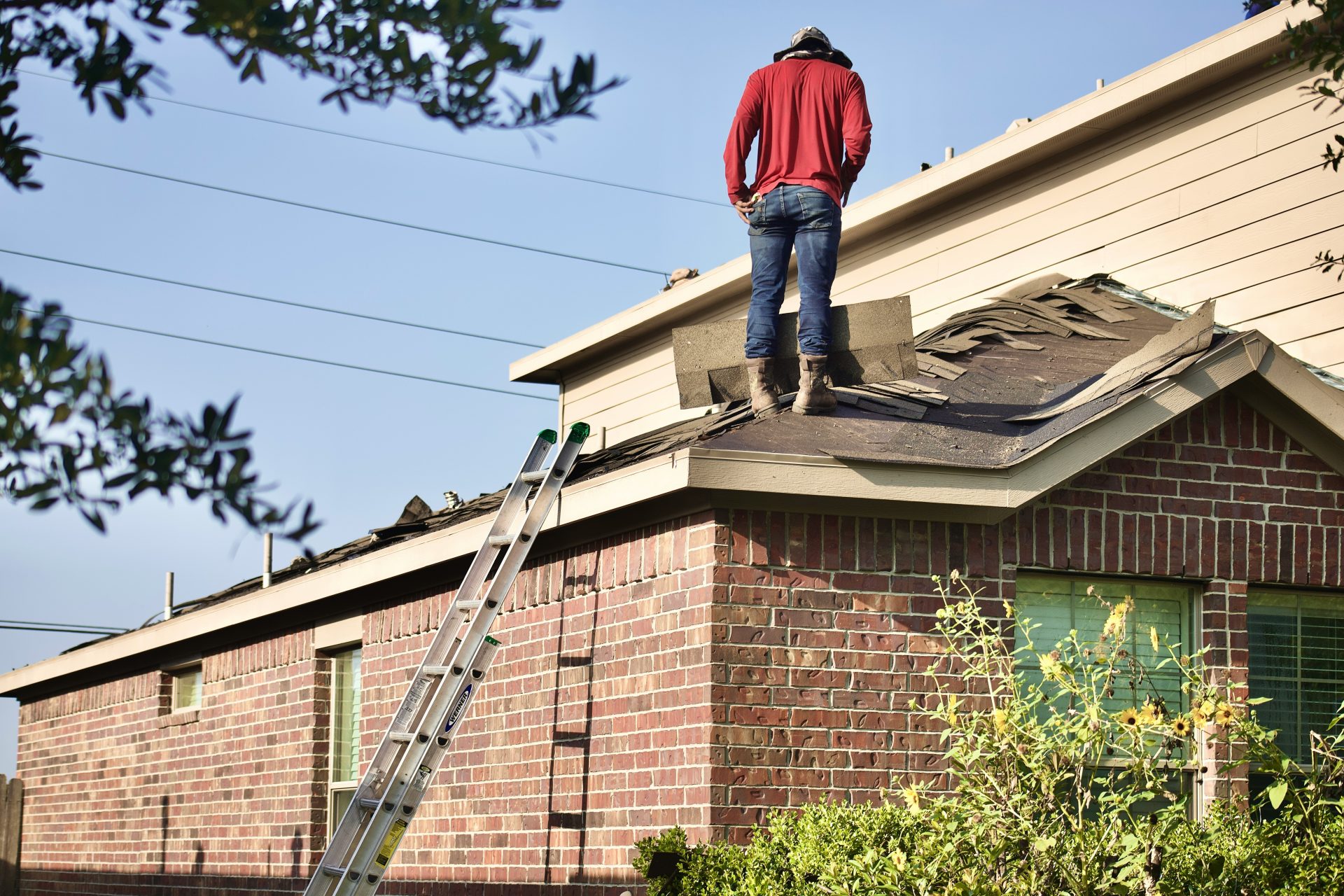 un homme debout sur le toit d'une maison